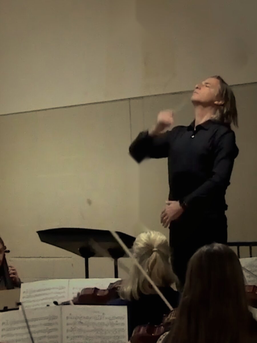 Andrew Spoeth conducting a string orchestra in rehearsal, Manchester